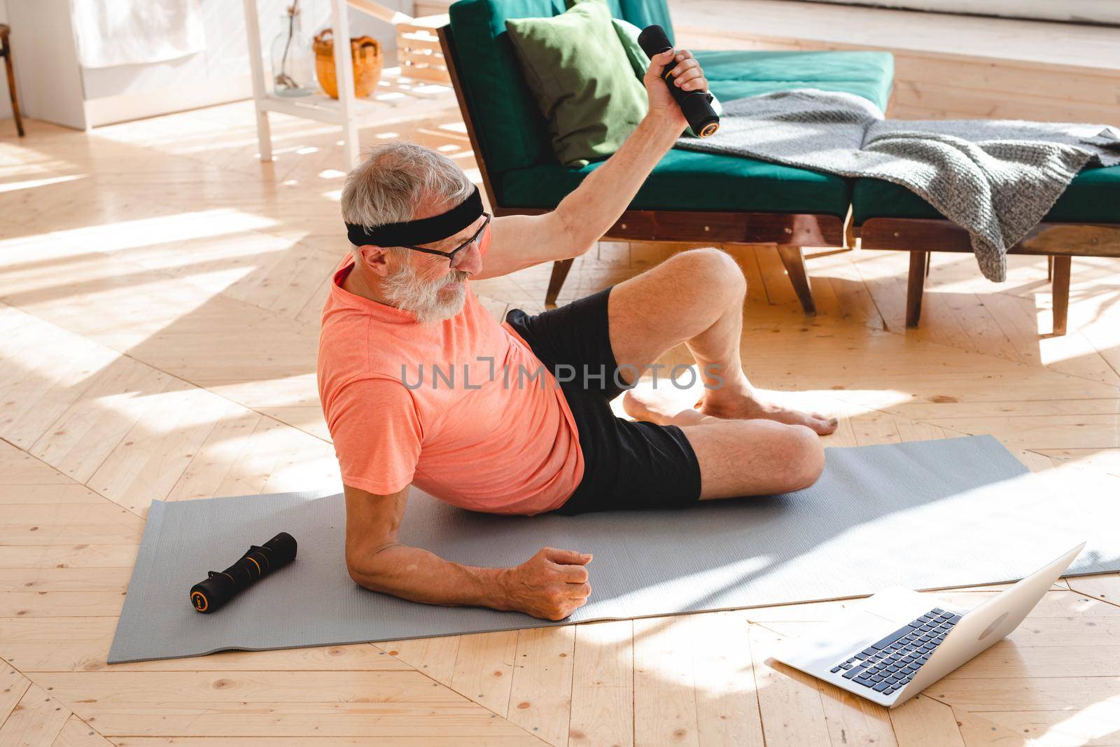 Senior man doing fitness exercise at home with dumbbells - elderly people and wellness health concept by Satura86