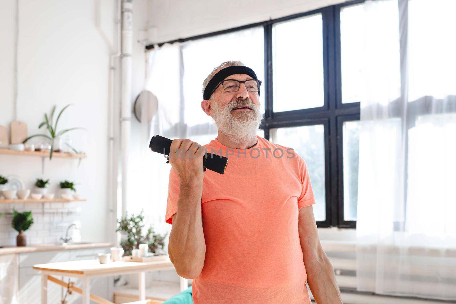 Senior man doing fitness exercises with virtual class and holding dumbbells - wellbeing and wellness concept by Satura86