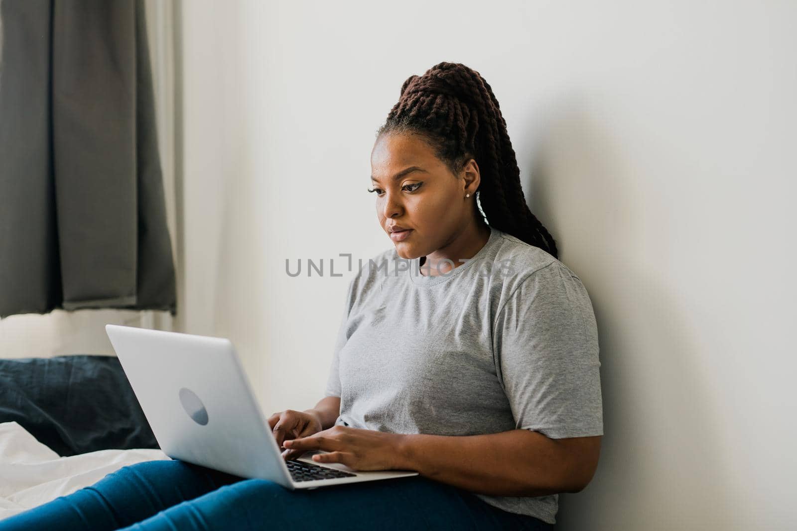 African american young woman using laptop on bed - technologies and communication and social network