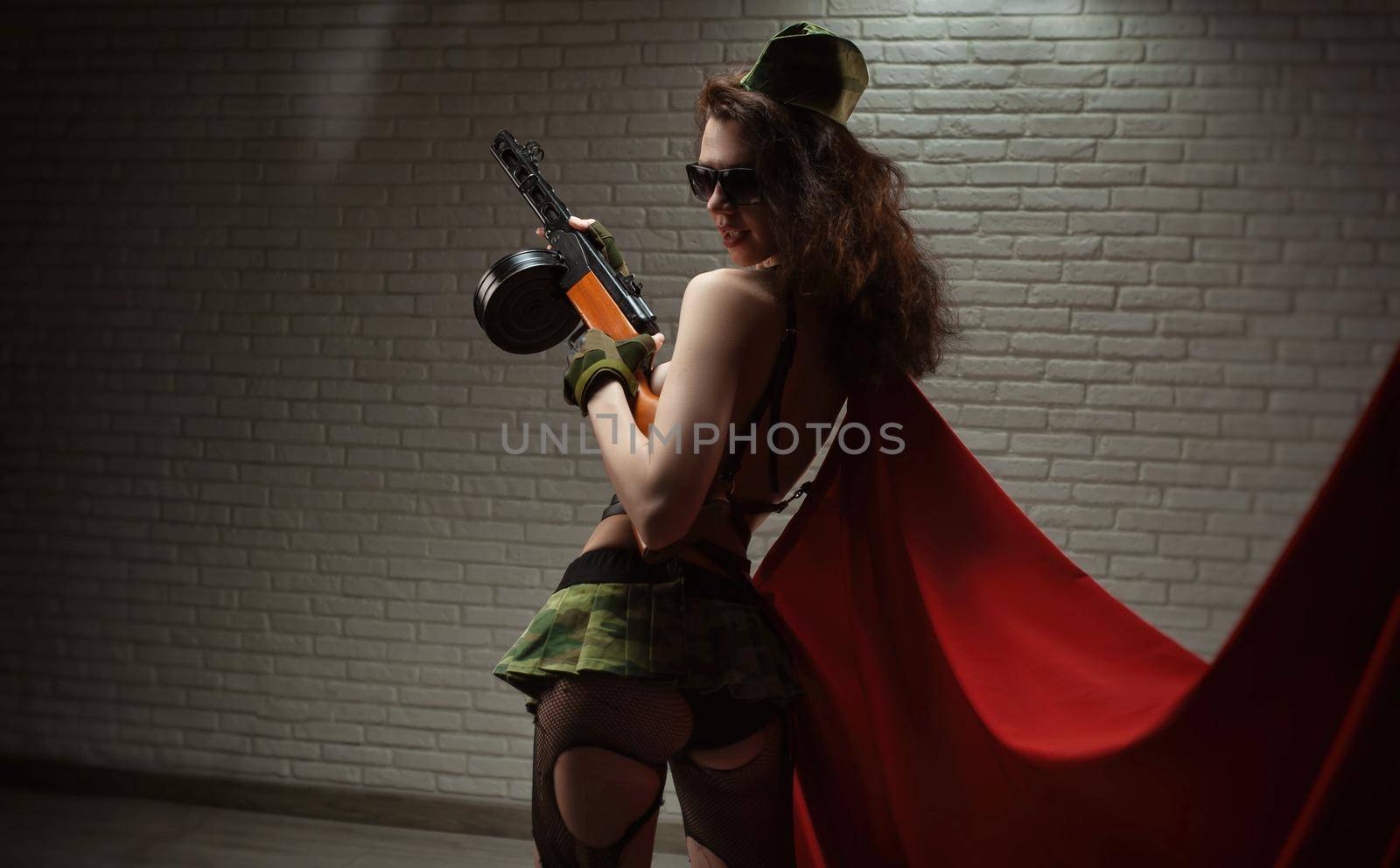 the sexy female soldier in sexy military uniform with a submachine gun