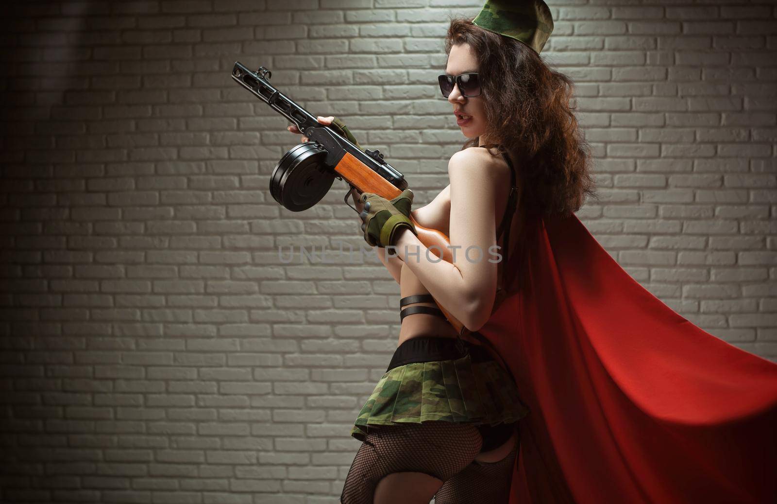 the sexy female soldier in sexy military uniform with a submachine gun