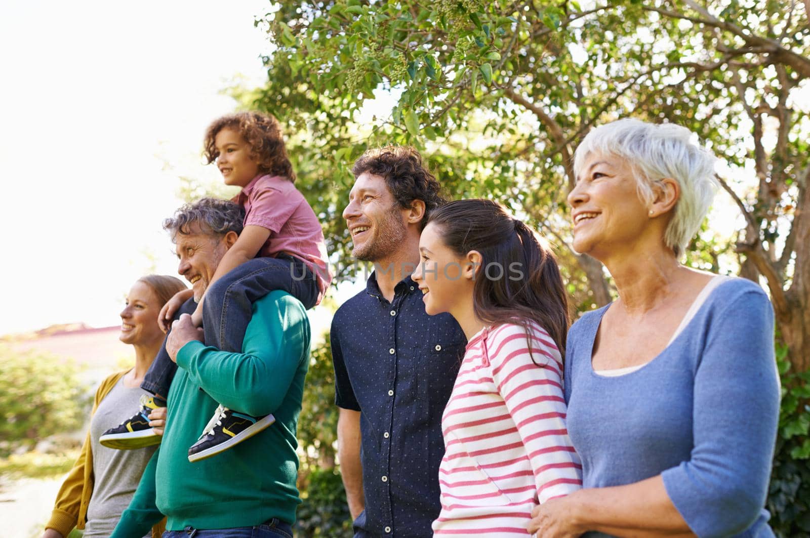 Shot of a family standing outdoors in the shade.