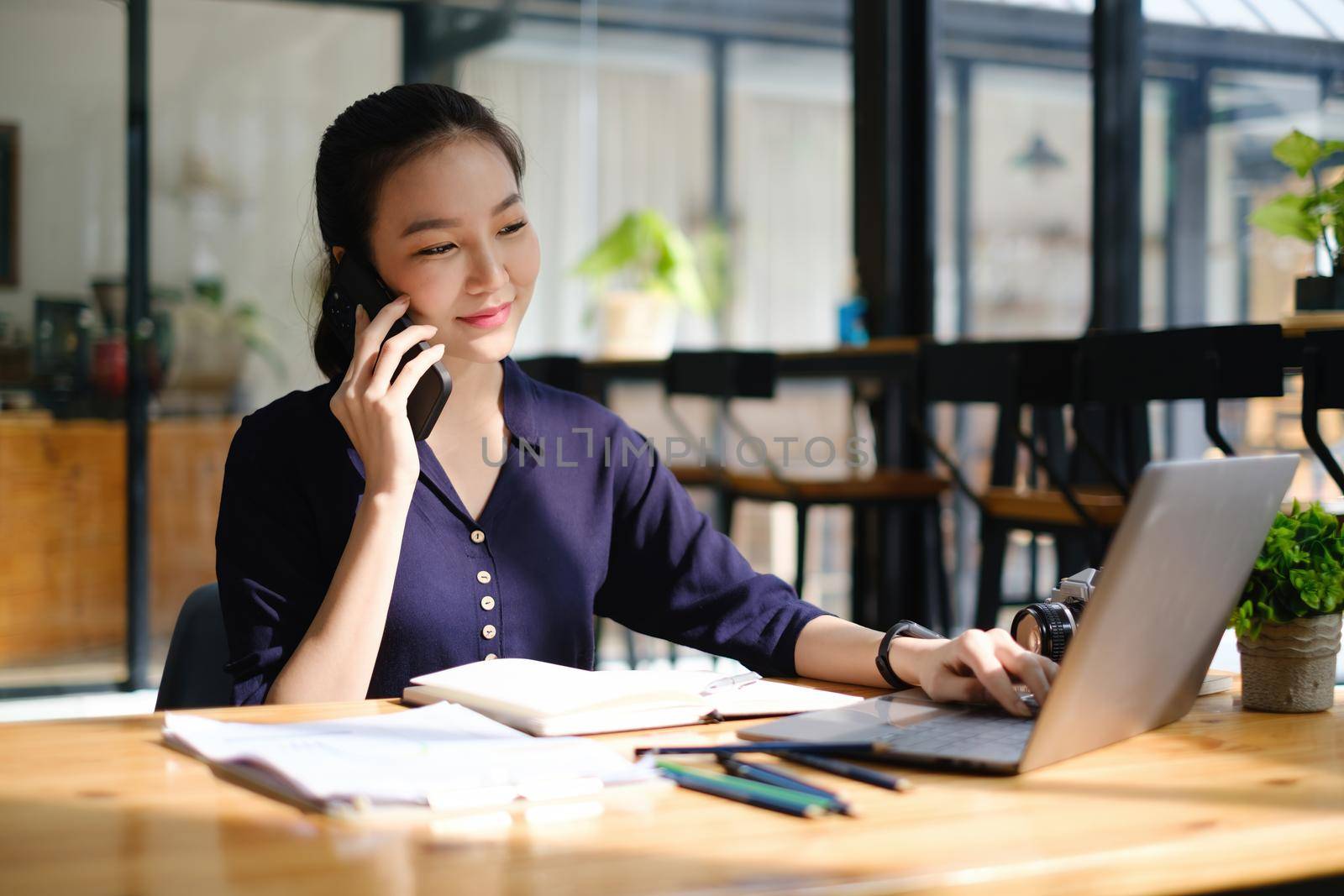 Business woman hand holding pen and cell phone with bank savings account application, account or saving money or insurance concept.