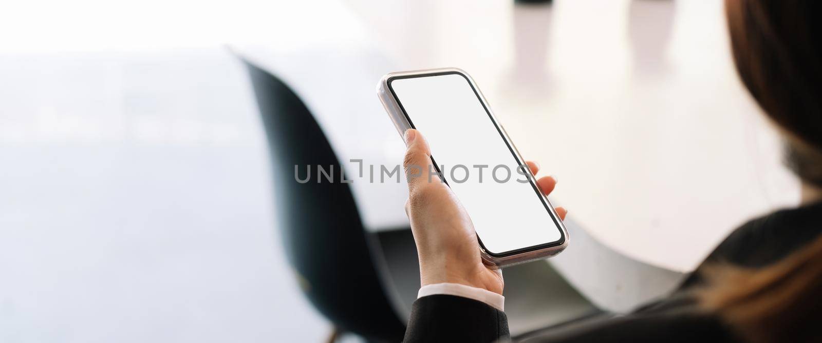 Close up woman hand holding mobile phone with blank screen for advertising.