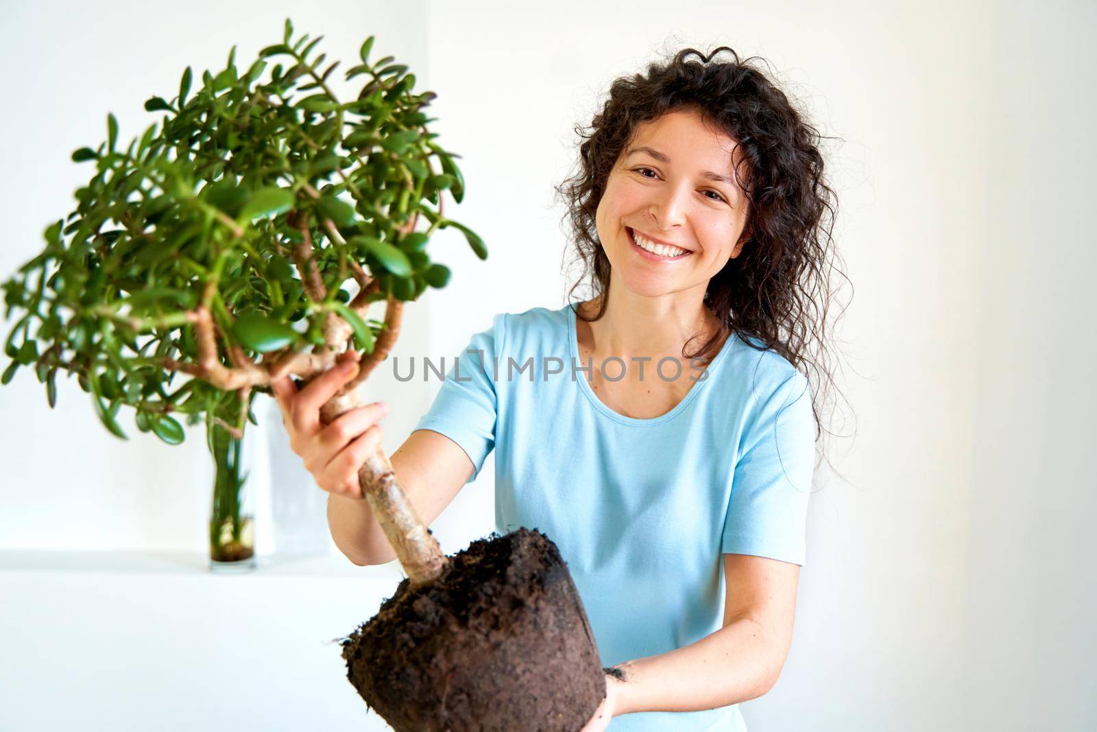 The girl is holding a large flower in her hands, which she transplants into a new pot.