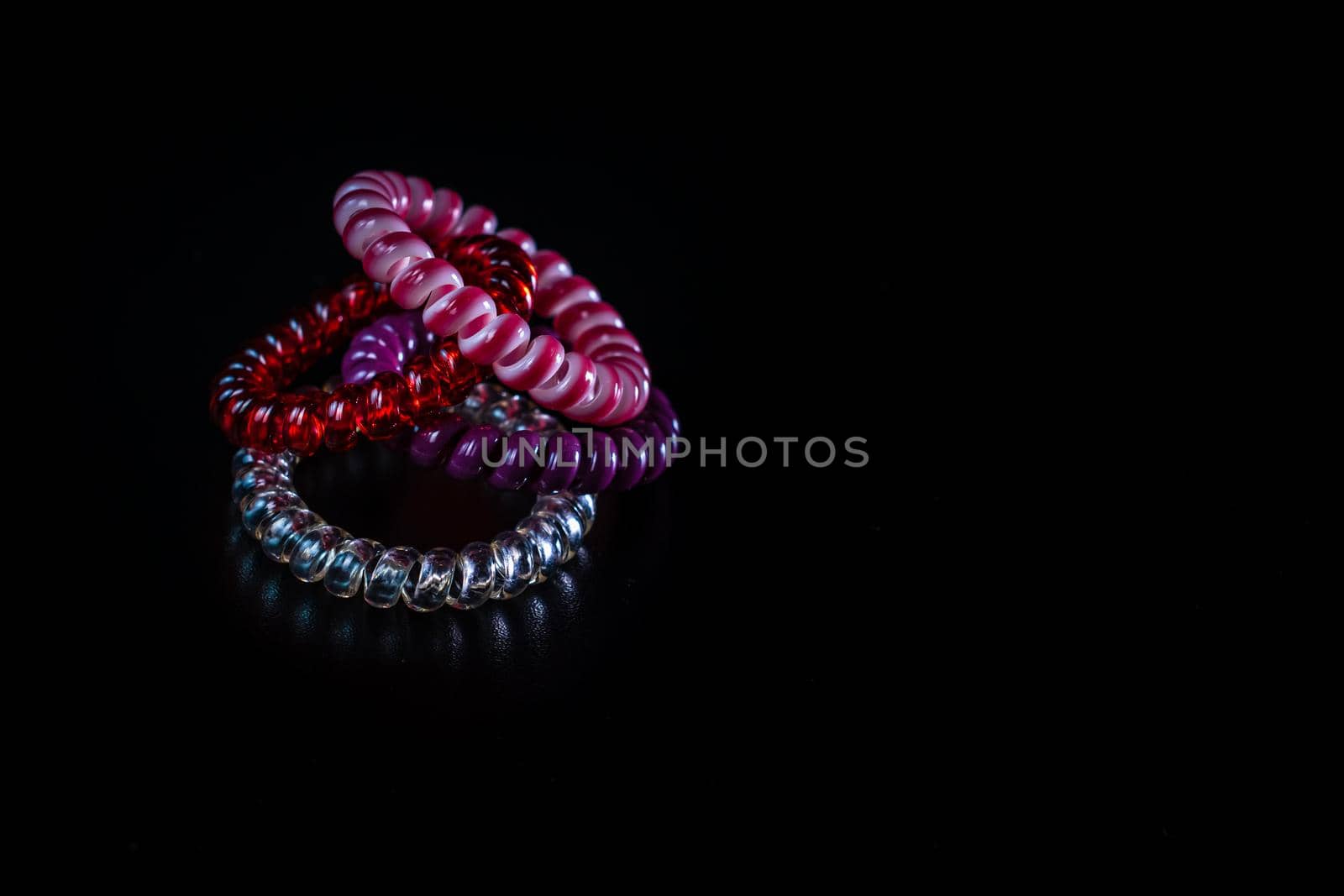 Hair spiral scrunchies on black background. Colorful scrunchies isolated.