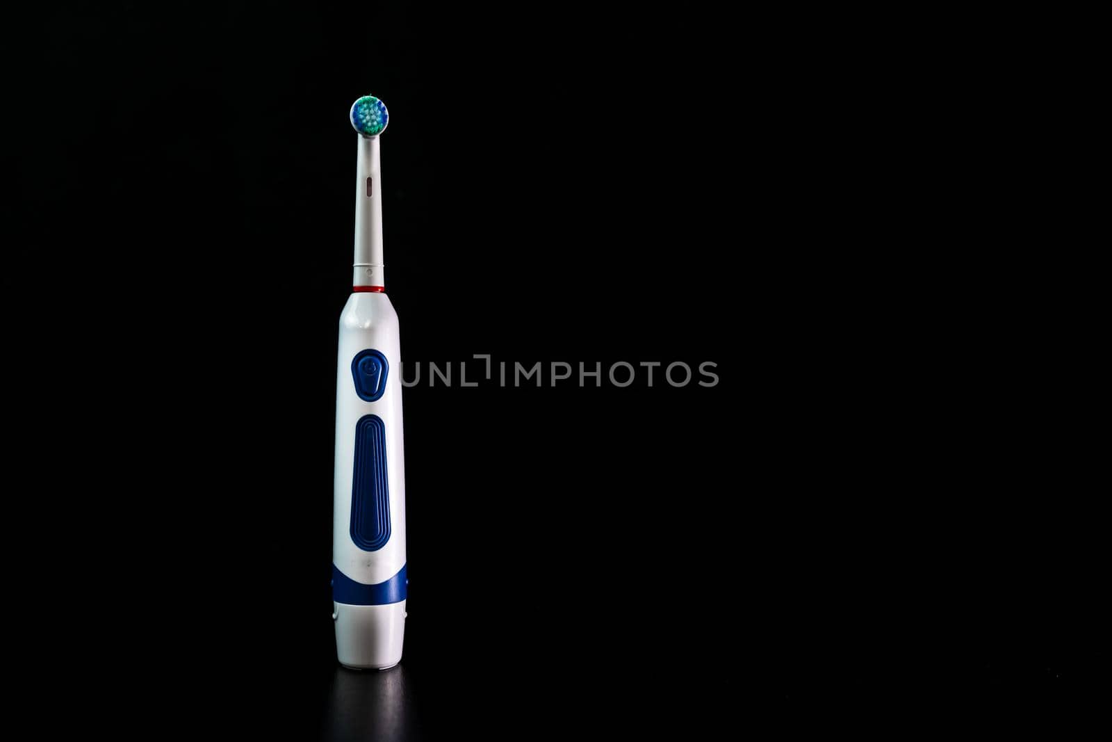 Close up of electric toothbrush isolated on black background. by vladispas