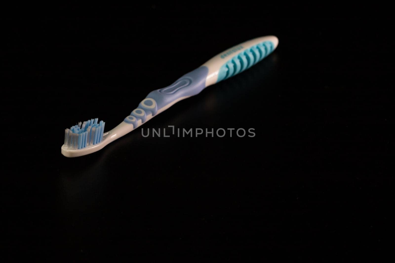 Selective focus on toothbrush isolated on black background.