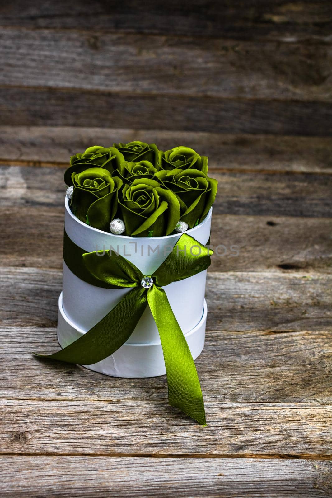 Green roses in a round luxury present box. Bouquet of flowers in a paper box isolated.