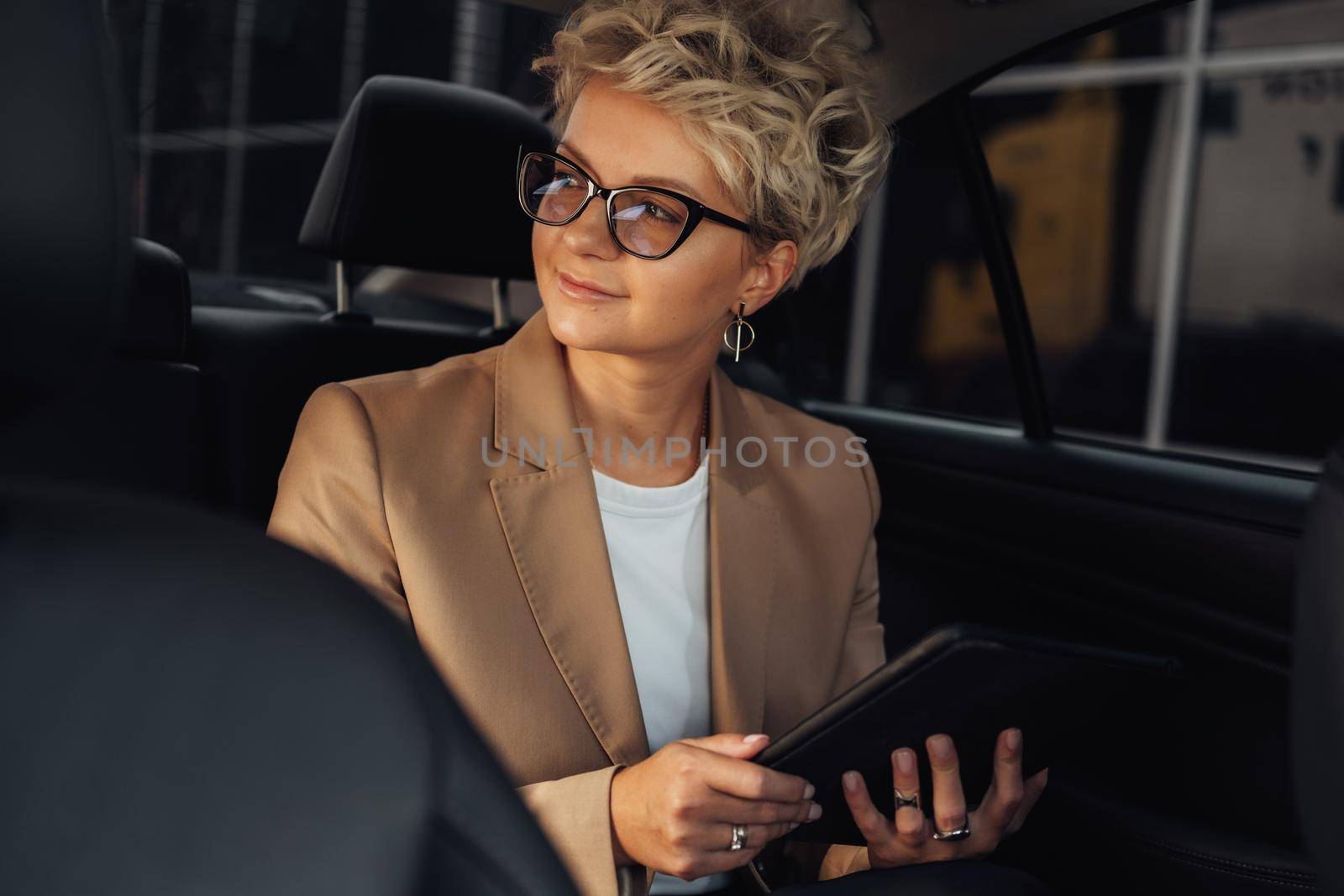 Female Entrepreneur Looking Through Window While Sitting on Back Seat of Luxury Car