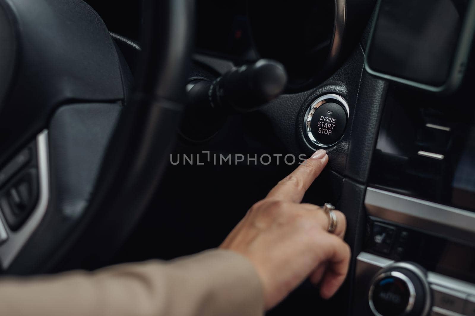 Woman Holding Finger on Button to Start or Stop Engine of the Modern Car