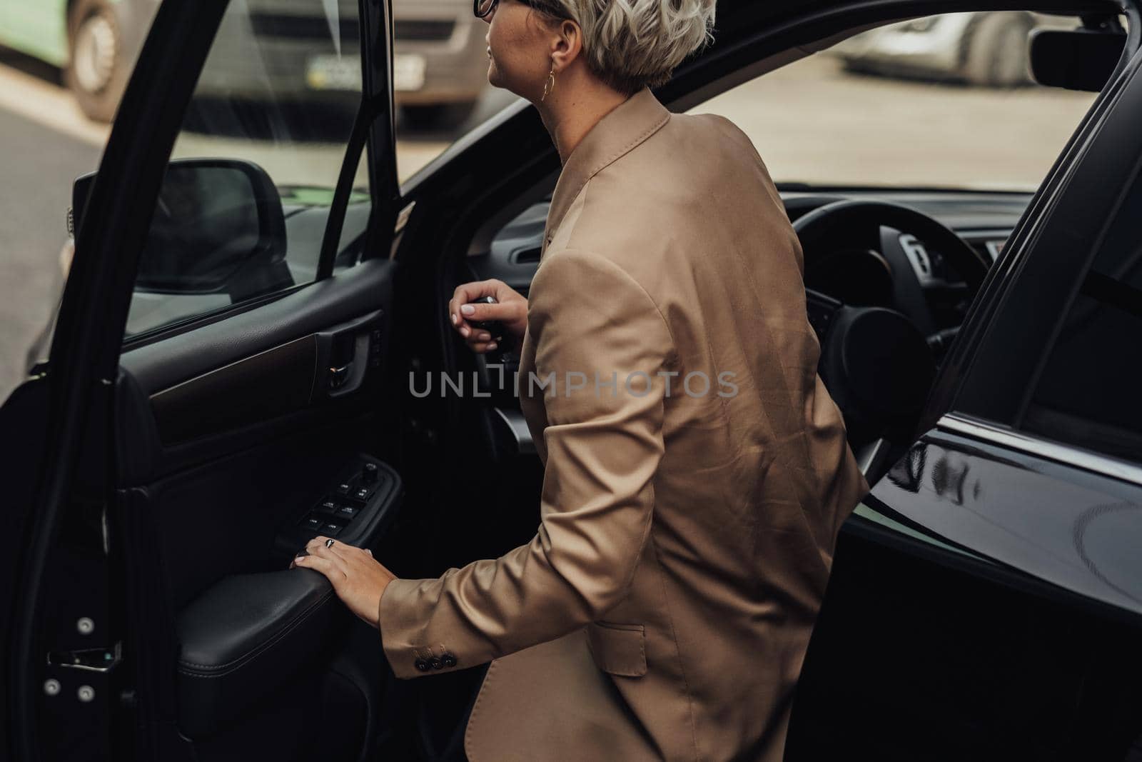 Woman Dressed in Rumpled Brown Jacket Getting from the Car