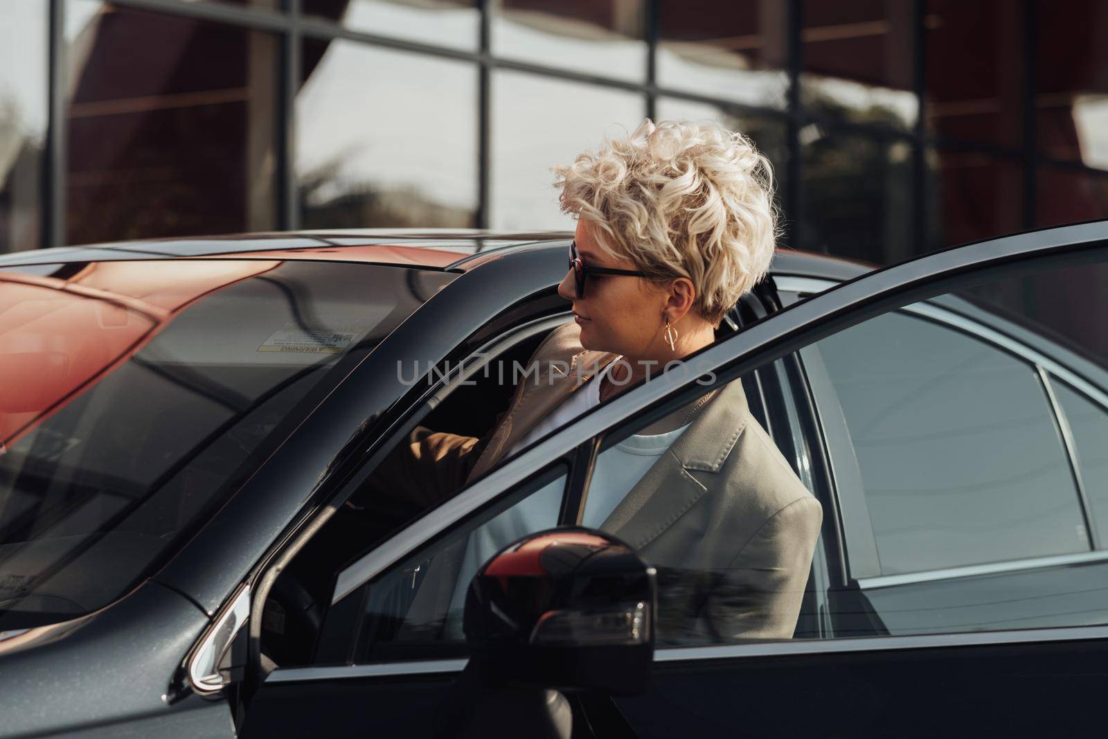 Elegant Woman Driver Getting in Luxury Car