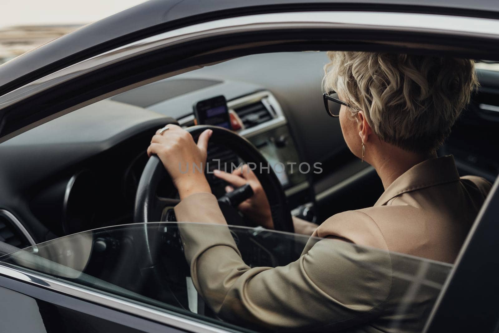Business Woman Using Smartphone While Driving Car, View from Side Window