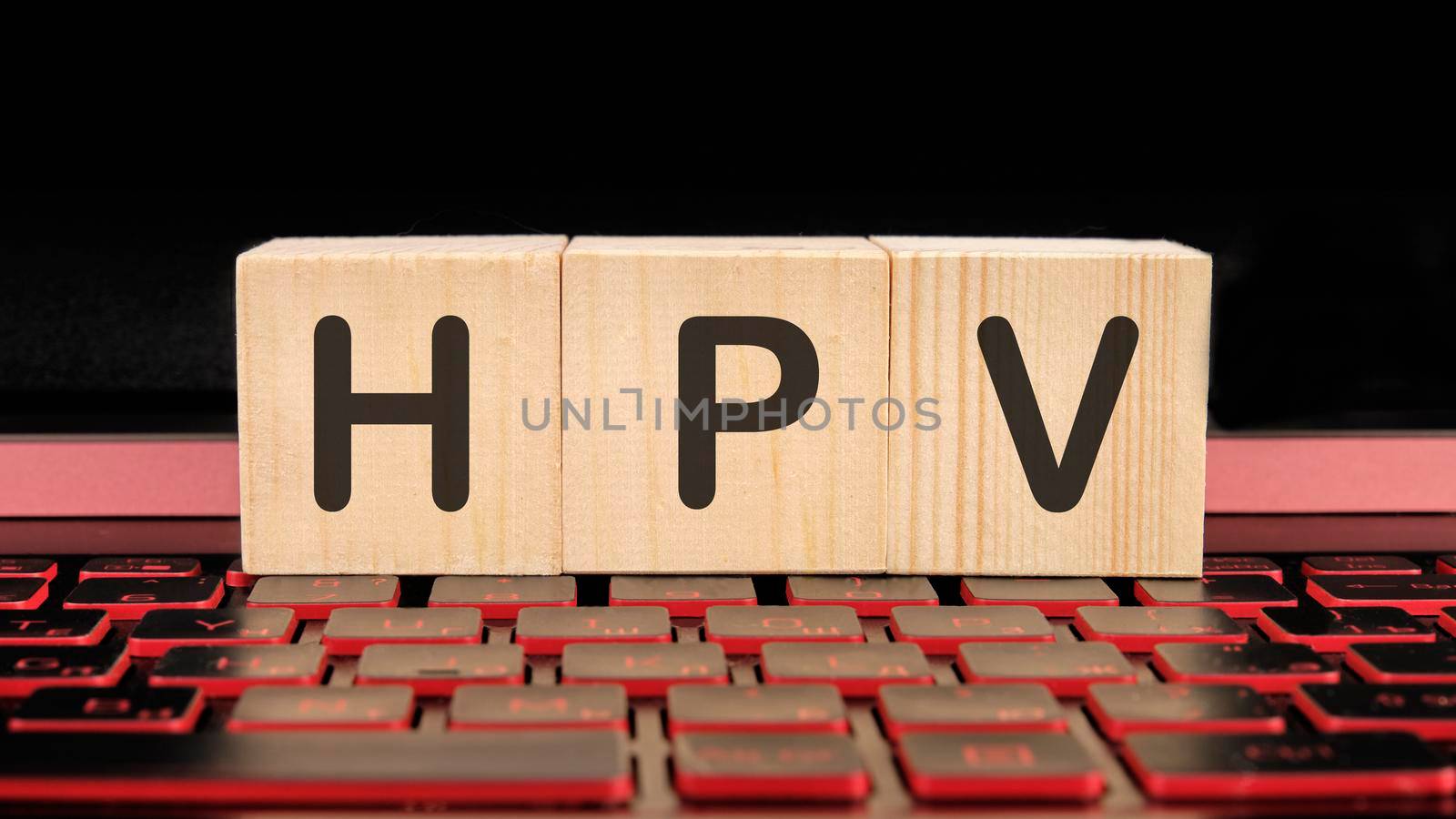 HPV the inscription on wooden cubes on the illuminated laptop keyboard.