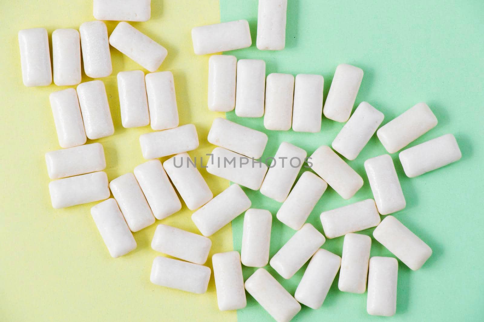 White chewing gums on the yellow and green background, high angle view