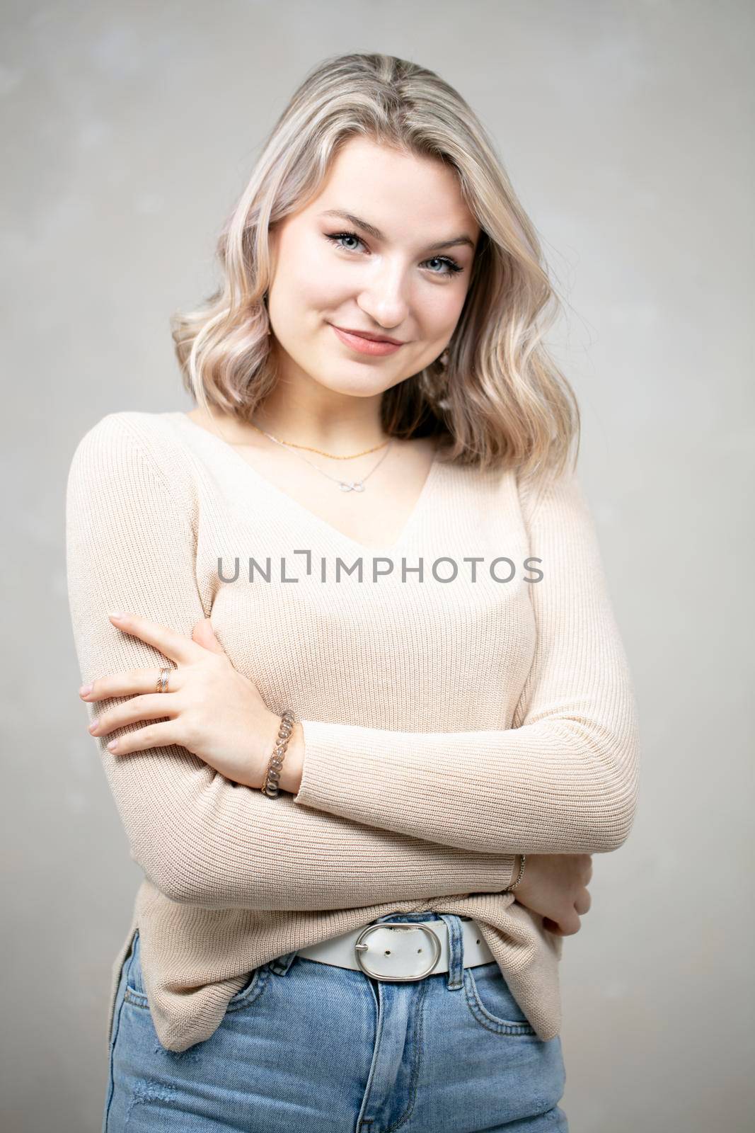 A beautiful young girl of European appearance looks at the camera and smiles. The girl is seventeen years old.