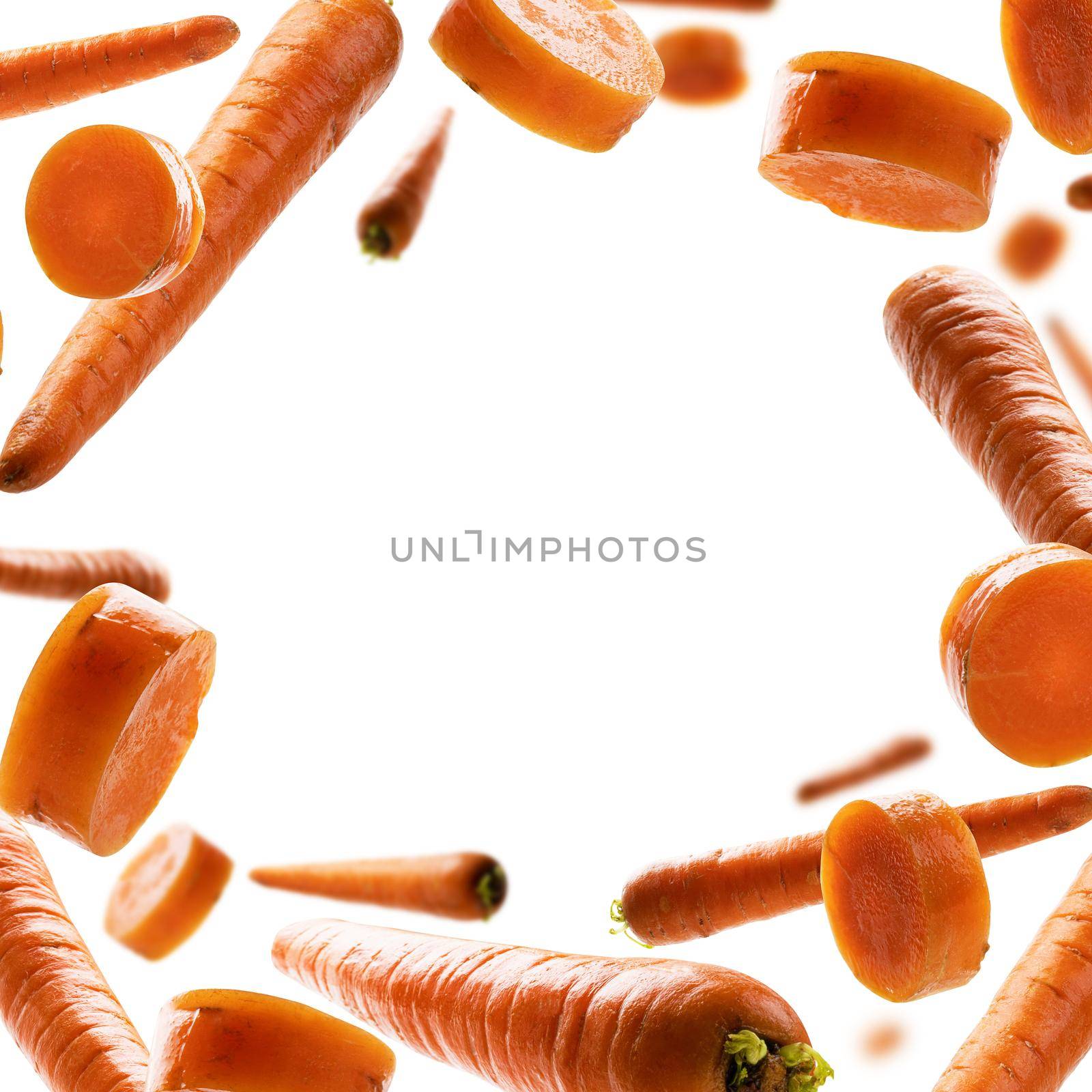 Ripe carrots whole and sliced levitate on a white background.