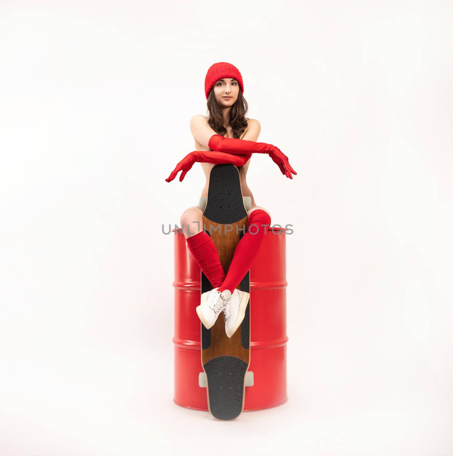 a naked skater girl with a longboard in a red hat and socks sits on a red barrel on a white background by Rotozey