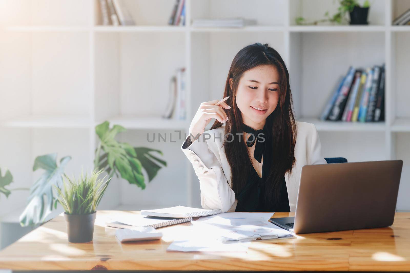 Young economists or accountants or financiers and investors are reviewing budget documents and using computers to study impact and risk assessments on corporate investment management