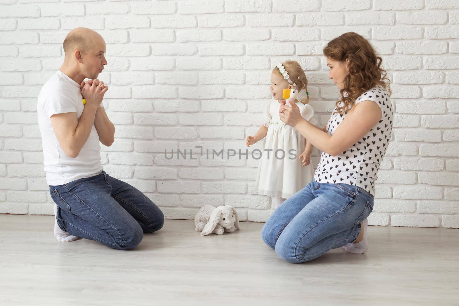 Baby child with hearing aids and cochlear implants plays with parents on floor. Deaf and rehabilitation concept by Satura86