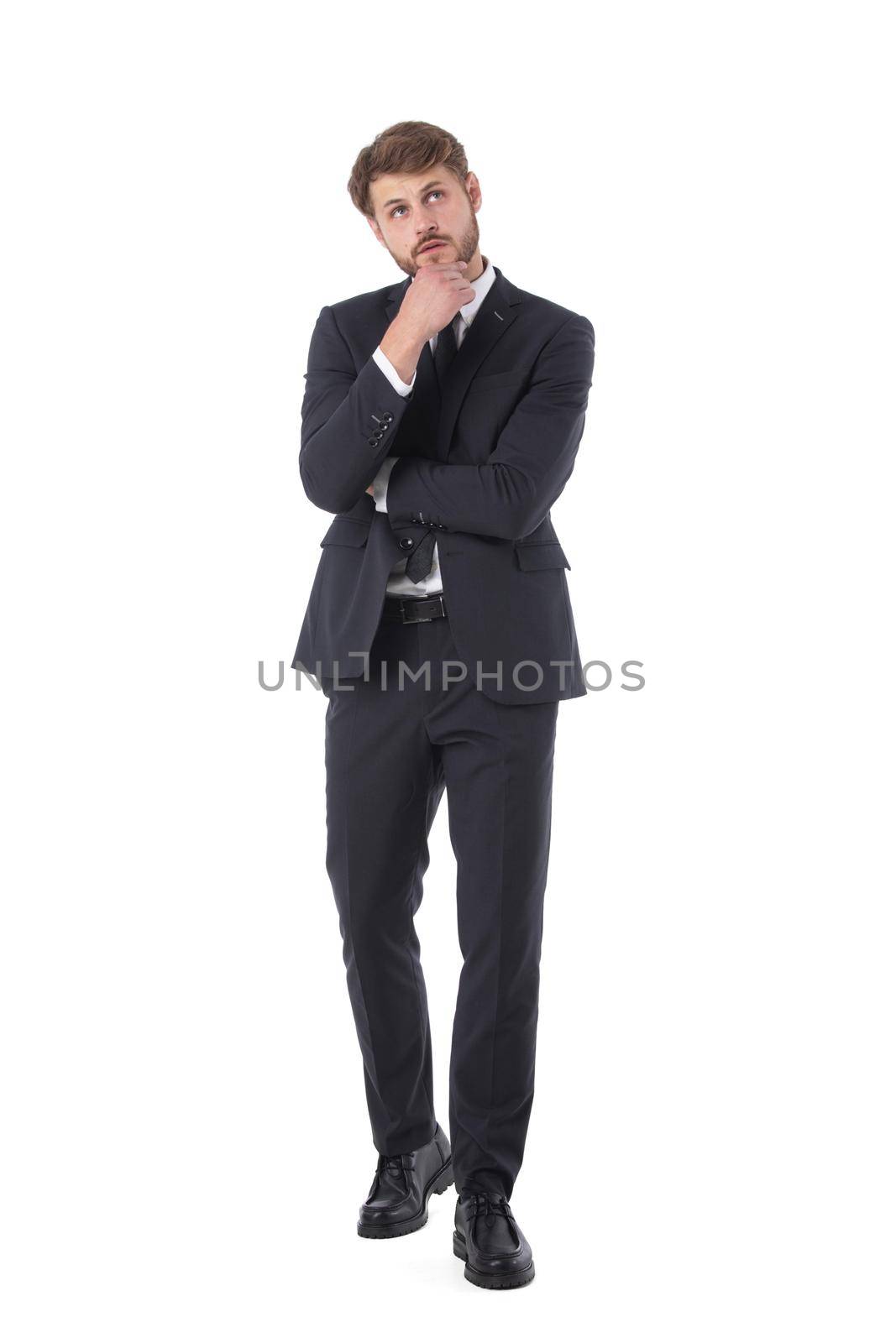 Thoughtful business man holding his hand under his chin full length studio portrait isolated on white background