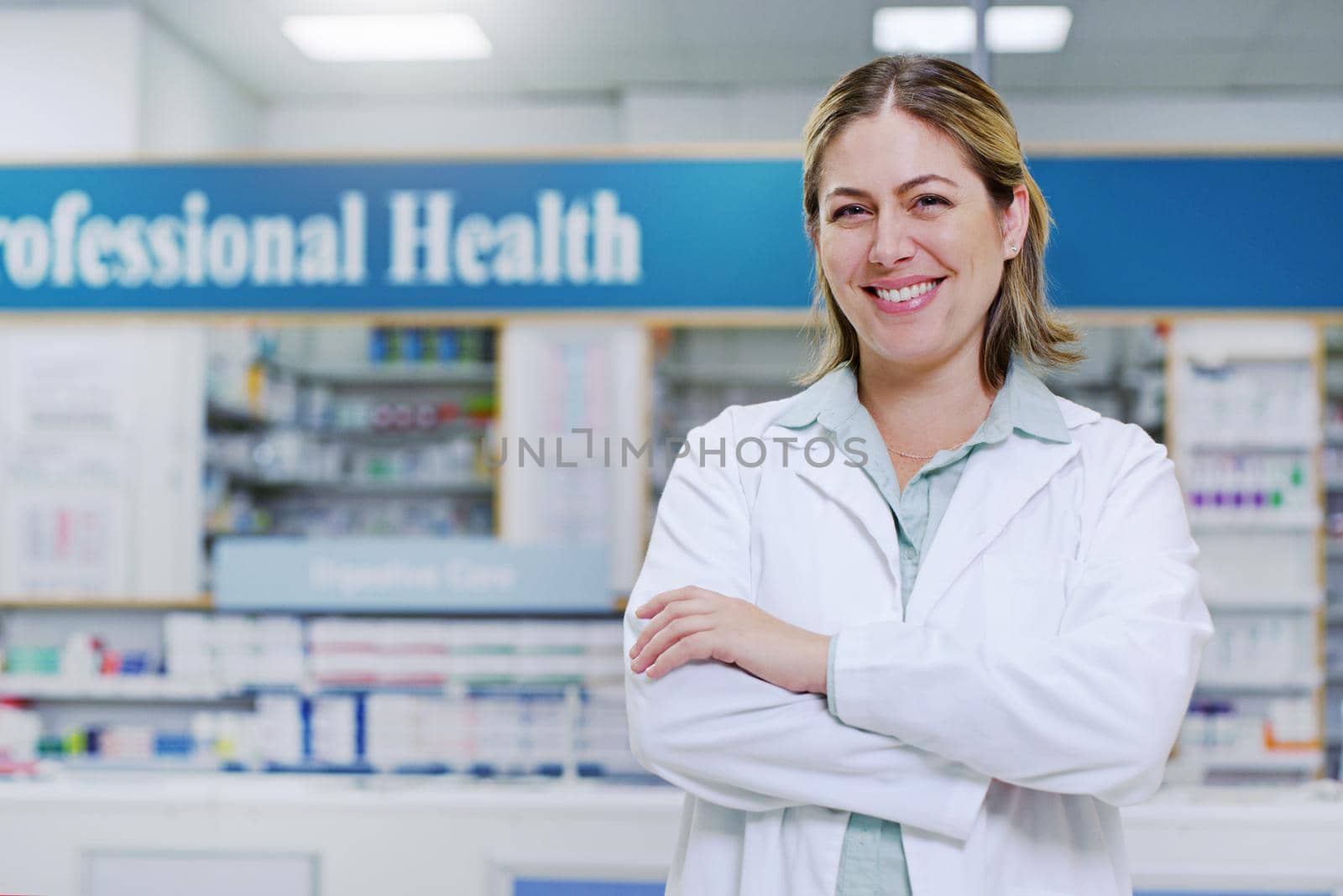 Always choose the people who put your wellbeing first. Portrait of a young pharmacist smiling and posing with her arms folded in a pharmacy. by YuriArcurs