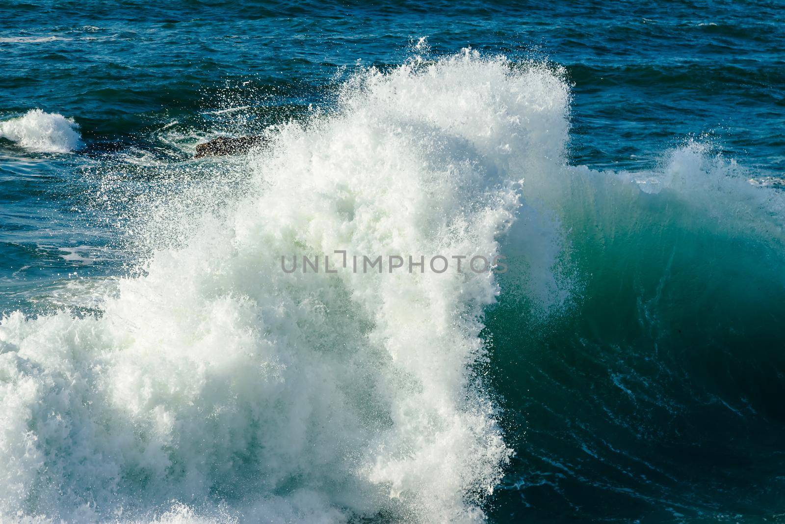 Wave breaking in the sea making foam.