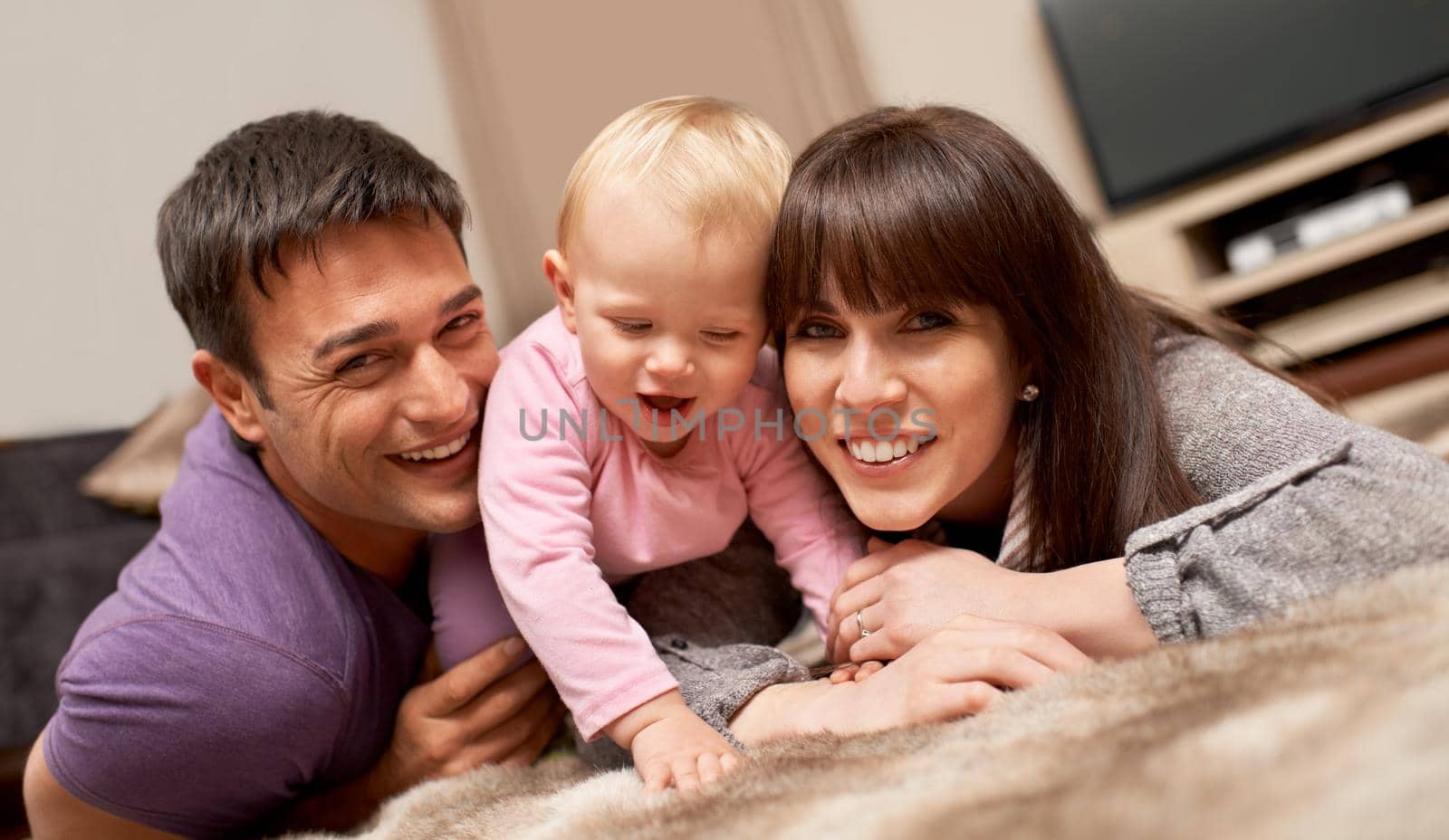 Shot of a young couple playing with their infant daughter.