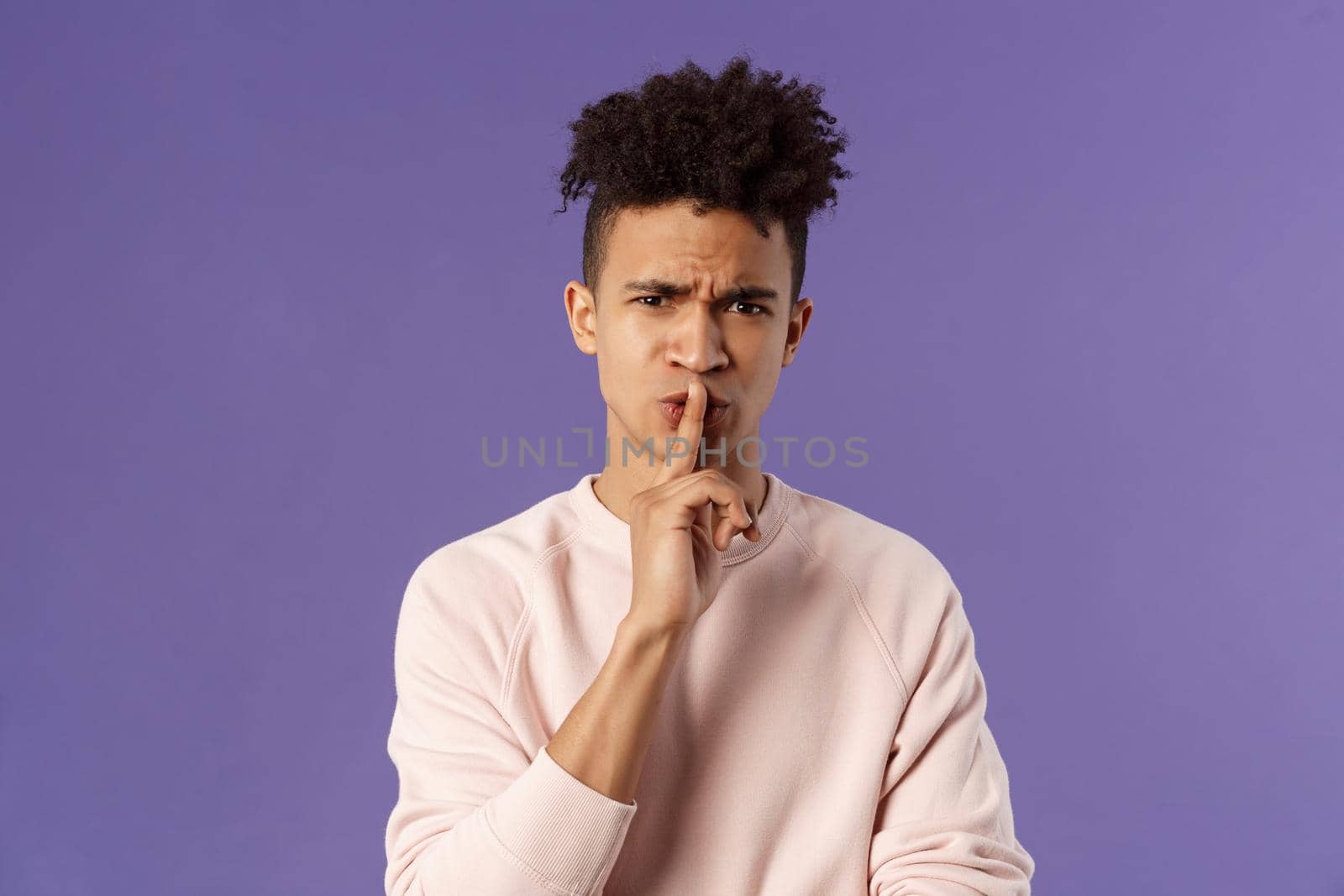 Show some respect. Portrait of angry and annoyed, displeased young hispanic man telling to keep quiet, shushing at someone being too loud, hold index finger over mouth frowning, scolding person by Benzoix