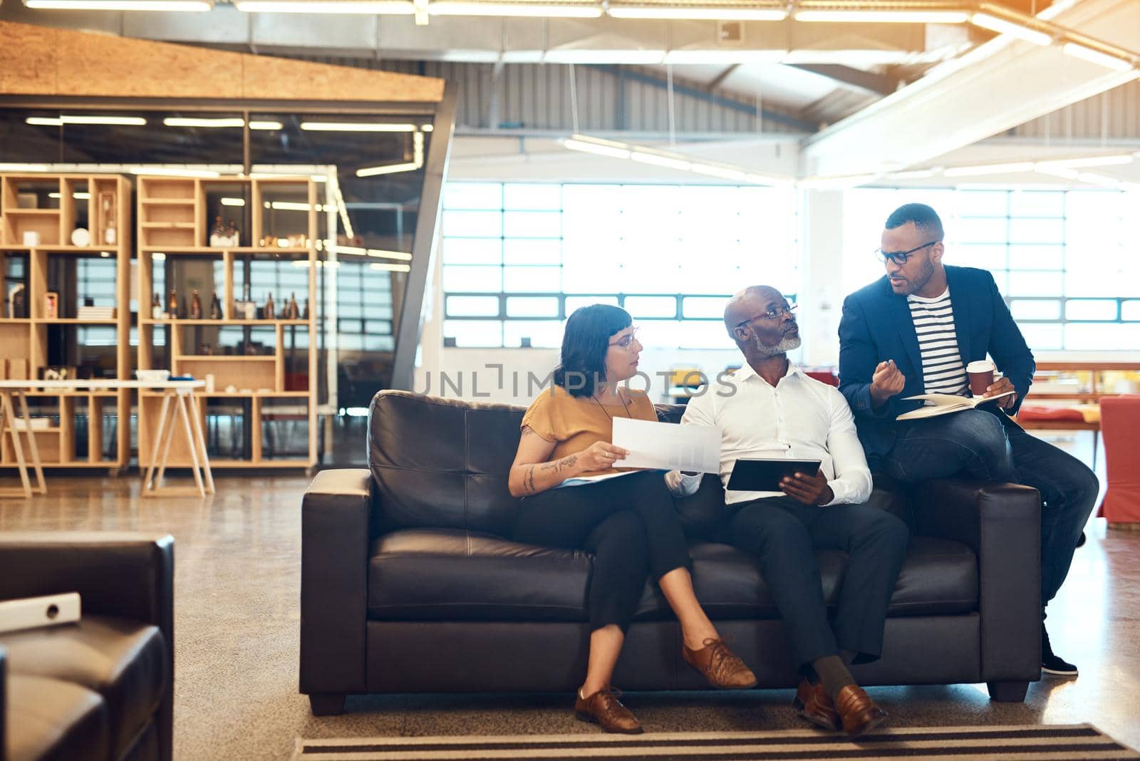 Good communication is the key to all successful collaborations. Full length shot of a group of designers having a discussion in an office. by YuriArcurs