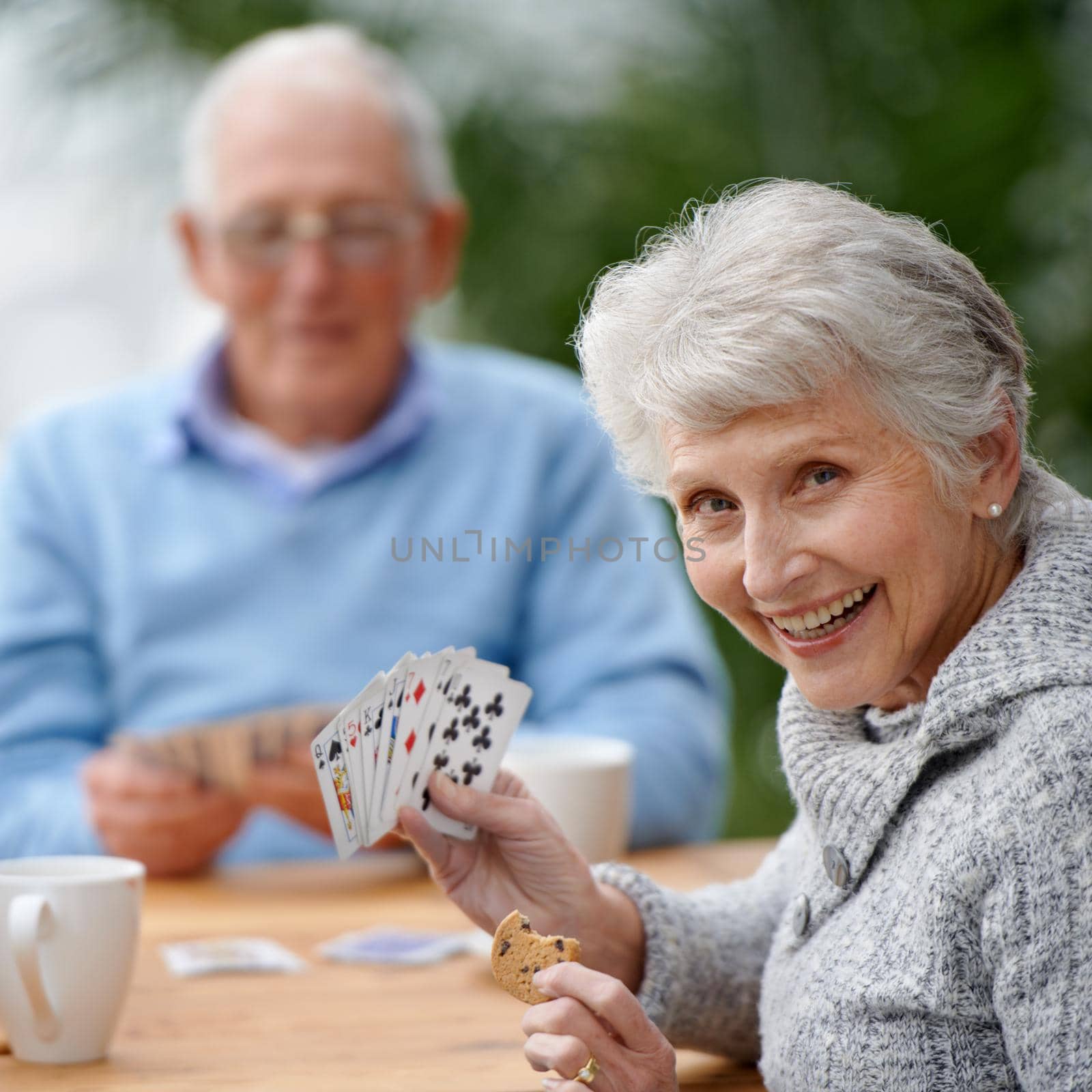 Two seniors playing cards together.