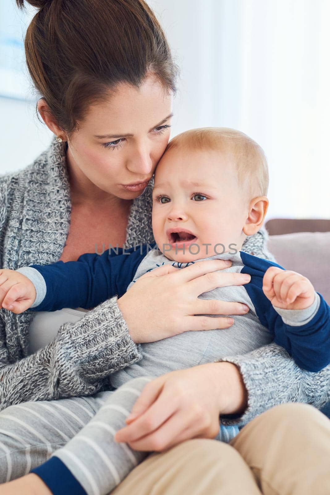 Cropped shot of a mother trying to console her crying baby boy at home.