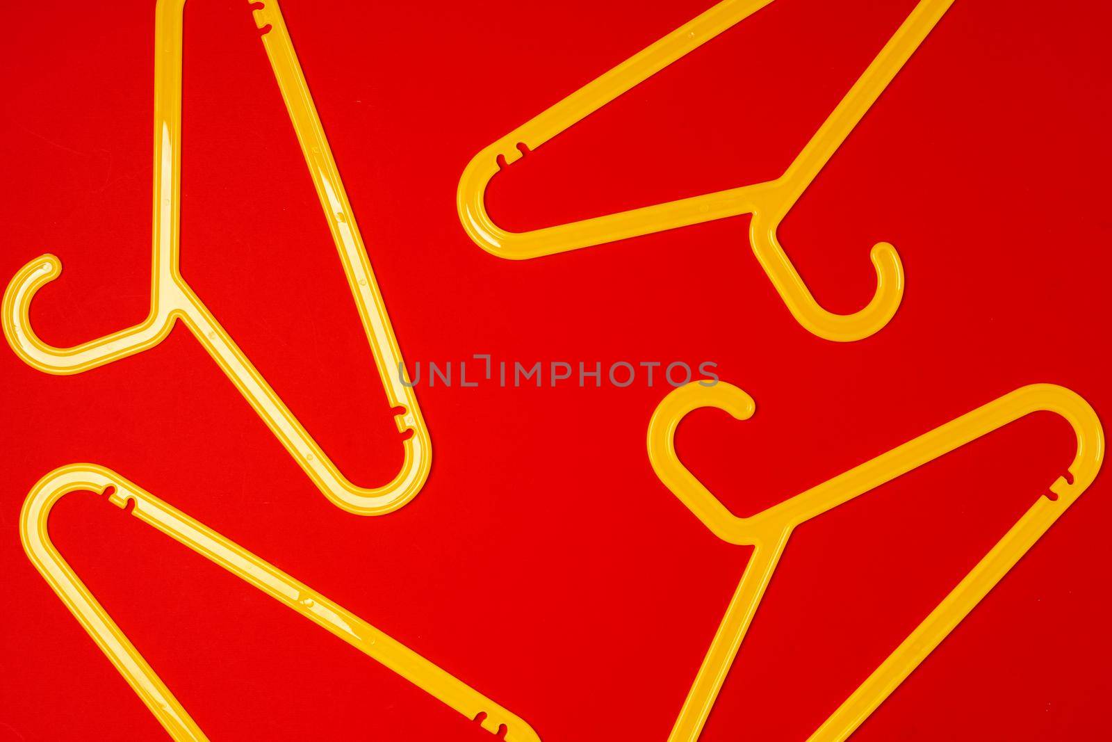 Hanger on red paper background. Minimalistic fashion concept.