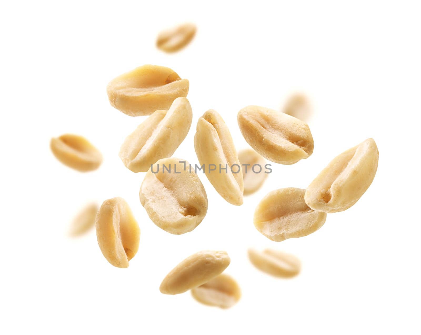 Peeled peanuts levitate on a white background.
