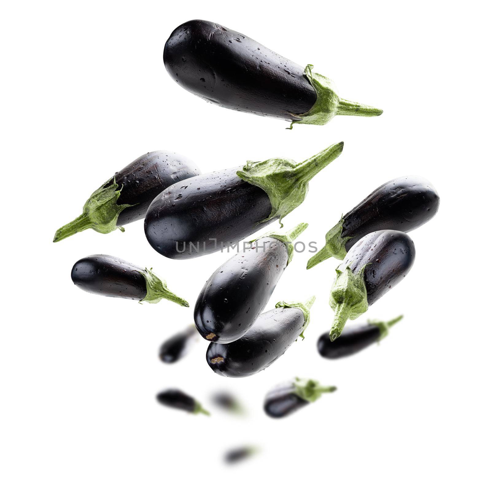 Ripe eggplants levitate on a white background.