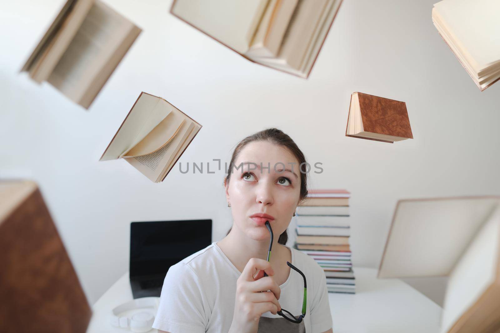 Portrait of a female student with books and glasses. Young female student reading books and preparing for exams. Creative photo