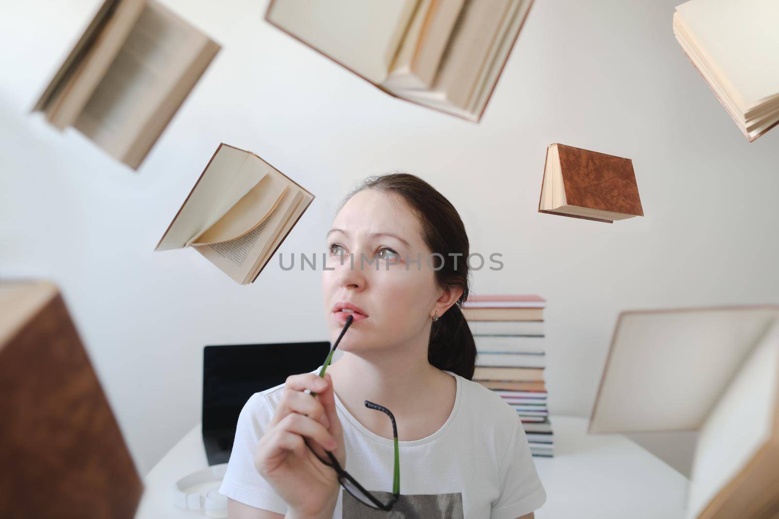 Portrait of a female student with books and glasses. Young female student reading books and preparing for exams. Creative photo
