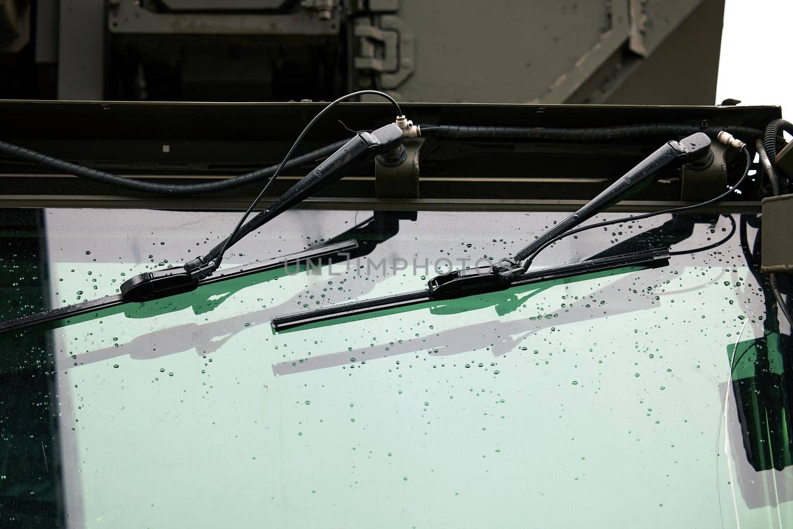 Wipers on the windshield of an armored car. Drops on the windshield armor glass. Windscreen of modern armored military truck by EvgeniyQW