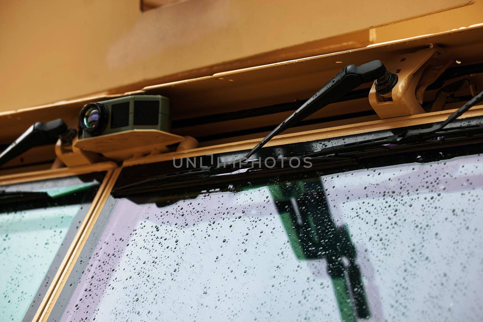 Wipers on the windshield of an armored car. Drops on the windshield armor glass. Windscreen of modern armored military truck.