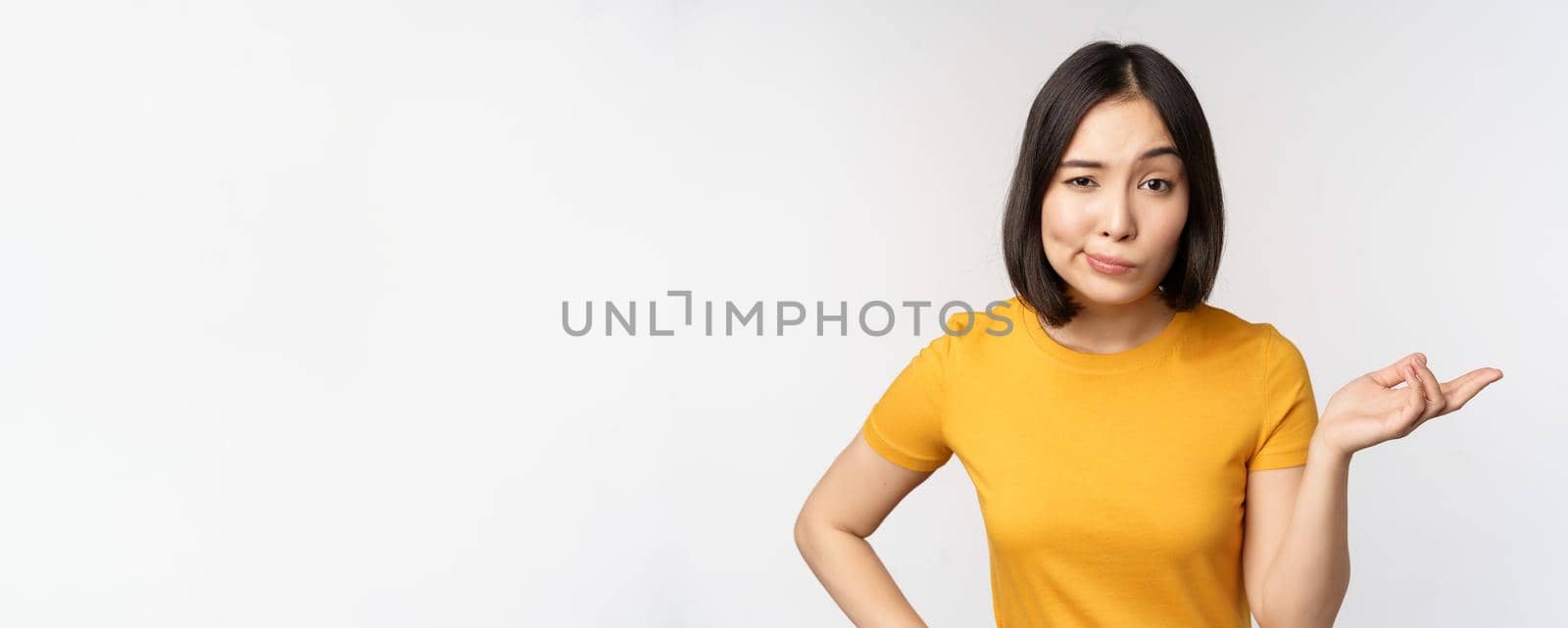 So what. Unbothered asian woman shrugging, looking clueless, standing against white background. Copy space