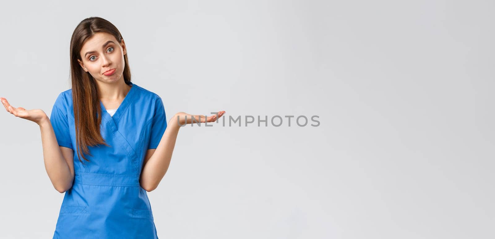 Healthcare workers, prevent virus, insurance and medicine concept. Indecisive and unsure cute nurse, doctor in blue scrubs, shrugging with hands sideways, pouting, dont know and cant tell by Benzoix