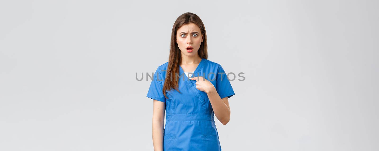 Healthcare workers, prevent virus, insurance and medicine concept. Confused and shocked female nurse in scrubs pointing at herself, gasping surprised, cant believe, being chosen or accused by Benzoix