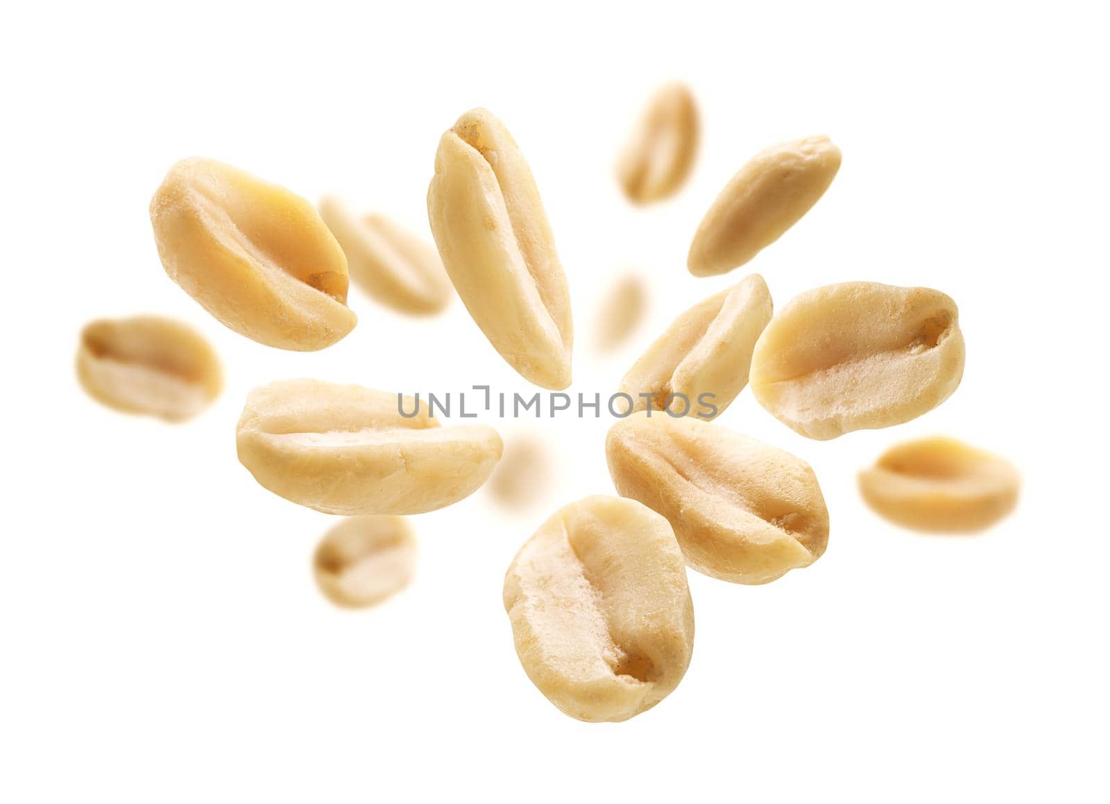 Peeled peanuts levitate on a white background.