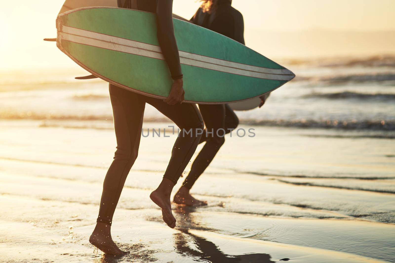 Shot of an unrecognizable young couple going surfing at the beach.