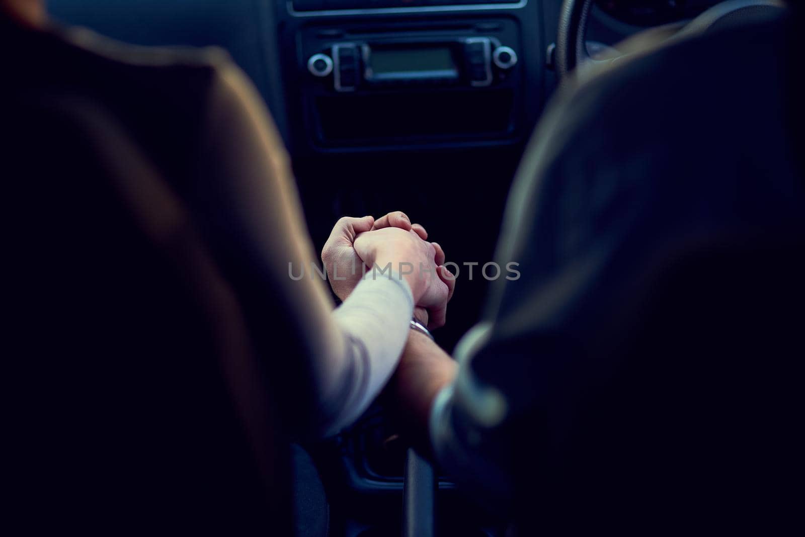 Getting away from everything but each other. Rearview shot of a unrecognizable couple holding hands while driving in a car. by YuriArcurs