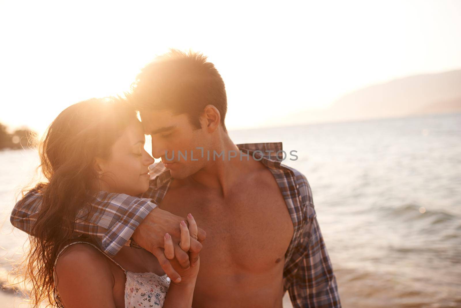 Getting closer. Shot of a young couple enjoying a beach getaway. by YuriArcurs