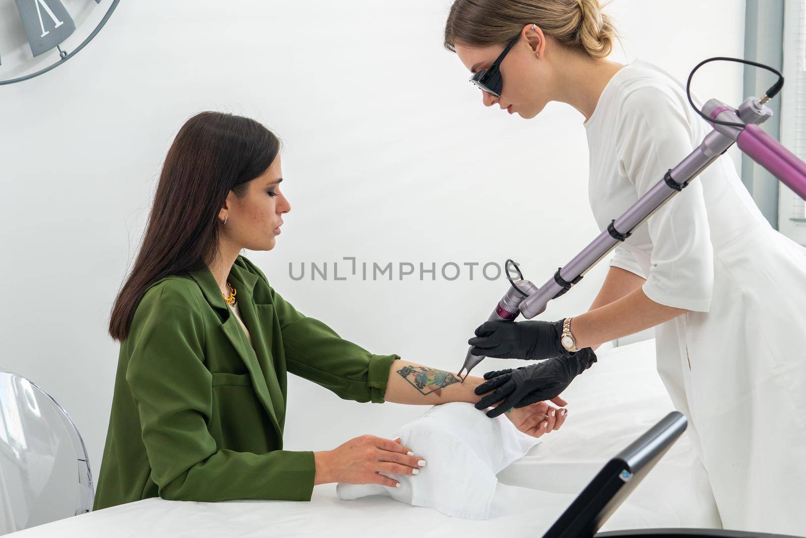 Cosmetologist removing tattoo with laser device female hand. Concept of erasing tattoos as expensive procedure in cosmetology clinic