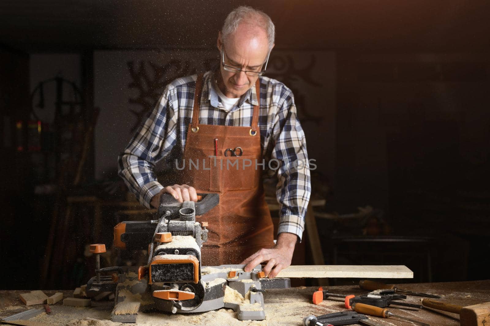 Carpenter using an electric circular saw, cutting a piece of wood. High quality photo.