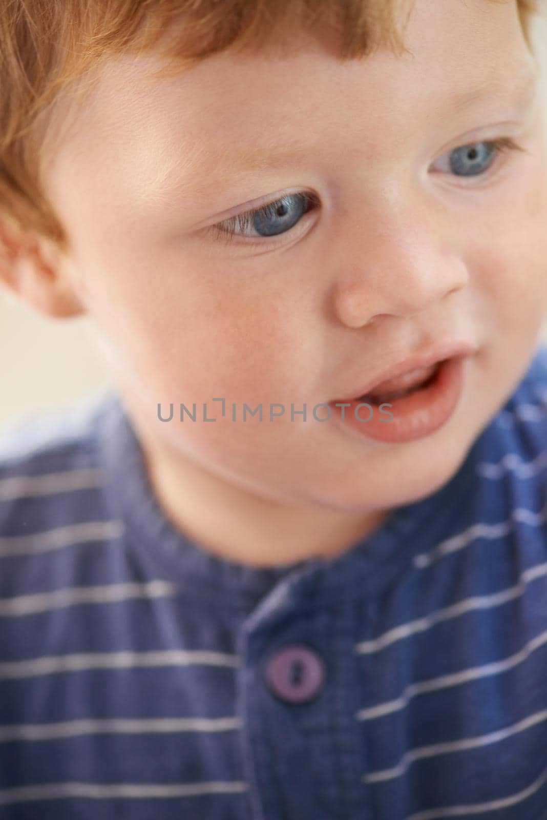 Filled with innocence. Cropped view of a cute red-headed toddler. by YuriArcurs